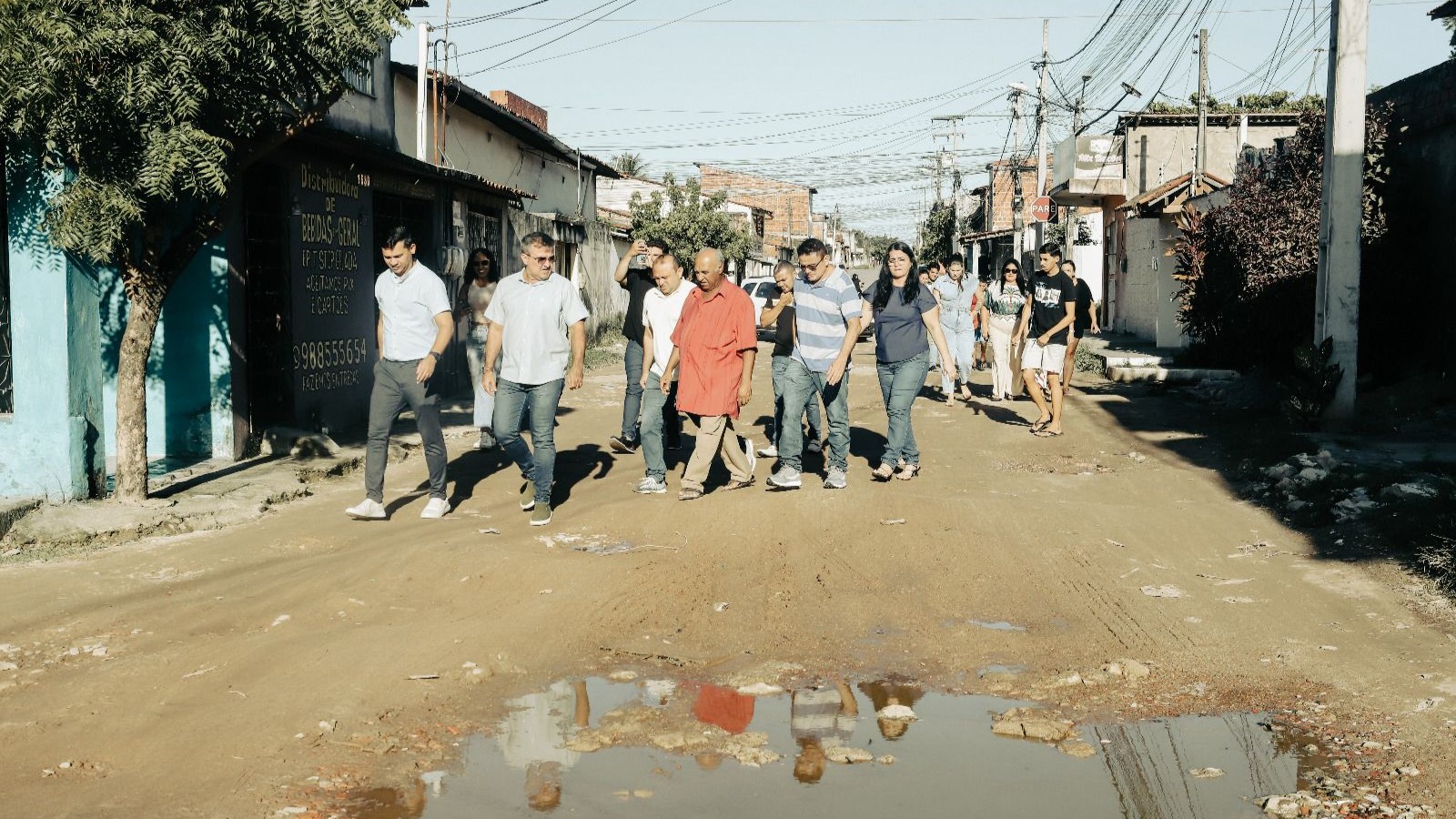 pessoas caminhando em uma rua sem calçcamento